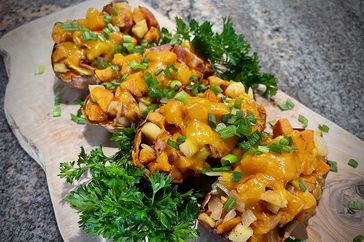 twice baked sweet potatoes with apples, bacon, and Cheddar on wooden board